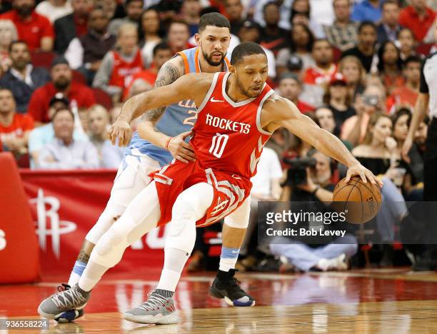 Eric Gordon of the Houston Rockets reaches for the ball as Austin Rivers of the LA Clippers looks on at Toyota Center on March 15, 2018 in Houston,...