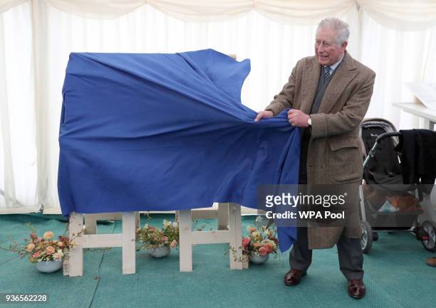 Prince Charles, Prince of Wales unveils a plaque for the development's new school, during a visit to Nansledan in Cornwall on March 22, 2018 in...