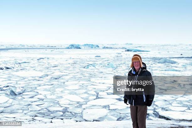 senior man standing in front of jokulsarlon lake - breidamerkurjokull glacier stock pictures, royalty-free photos & images