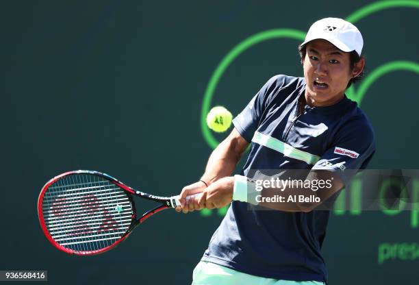 Yoshihito Nishioka of Japan plays a shot against Alex de Minaur of Australia during Day 4 of the Miami Open at the Crandon Park Tennis Center on...