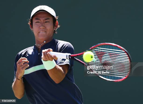 Yoshihito Nishioka of Japan plays a shot against Alex de Minaur of Australia during Day 4 of the Miami Open at the Crandon Park Tennis Center on...