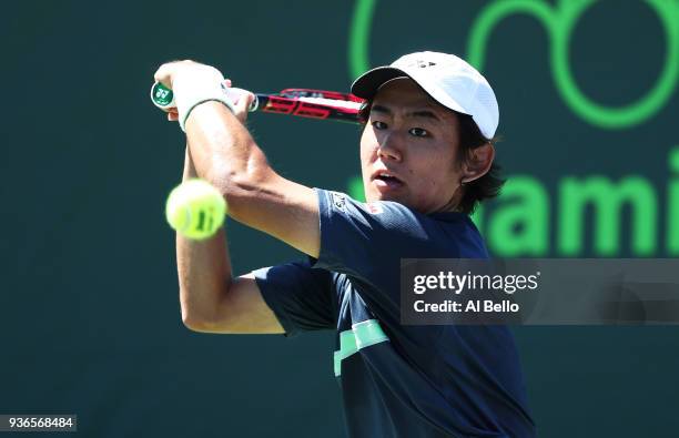 Yoshihito Nishioka of Japan plays a shot against Alex de Minaur of Australia during Day 4 of the Miami Open at the Crandon Park Tennis Center on...