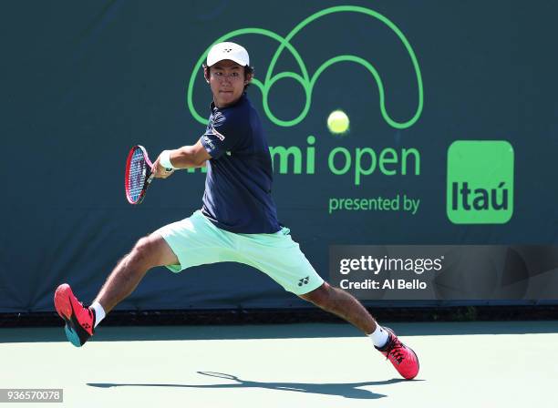 Yoshihito Nishioka of Japan plays a shot against Alex de Minaur of Australia during Day 4 of the Miami Open at the Crandon Park Tennis Center on...