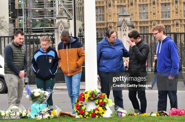Man reacts as he looks at floral tributes left in Parliament Square on the first anniversary of the Westminster Bridge terror attack on March 22,...