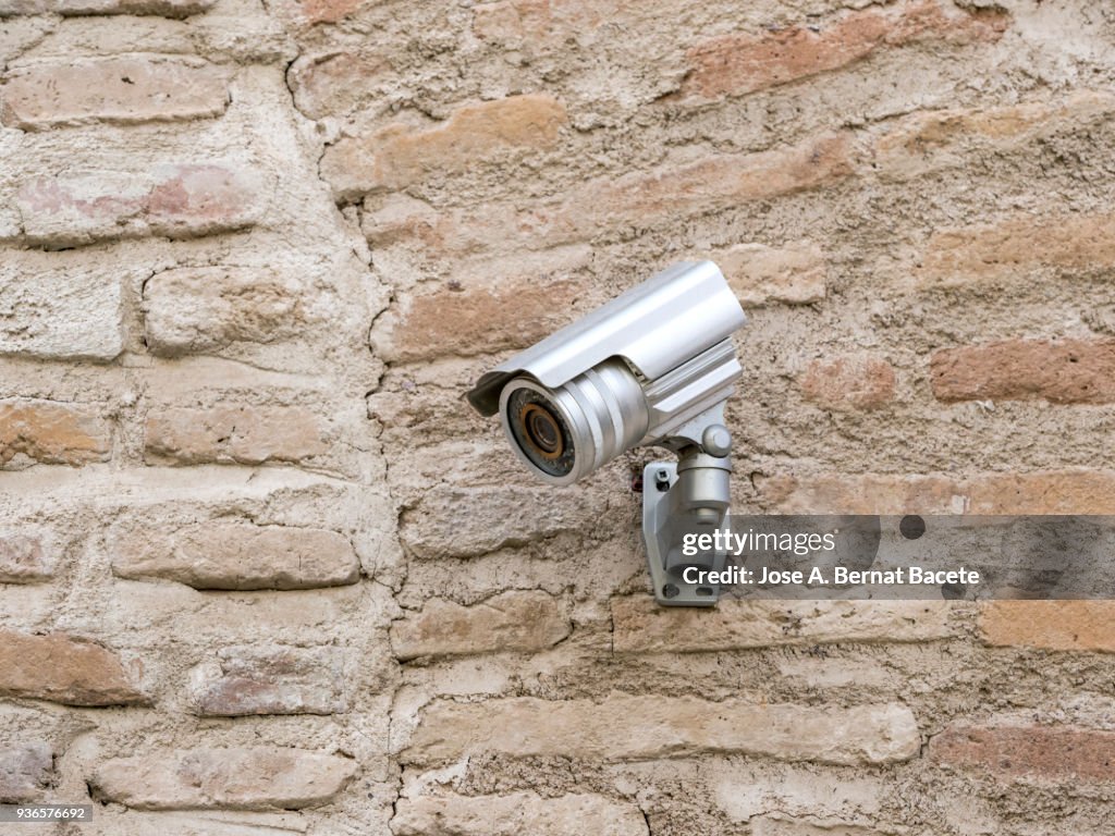 Security camera on an ancient wall of bricks.