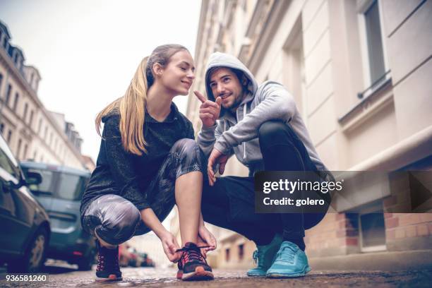 junge paar schuhe zu binden, an straßen - fashion couple stock-fotos und bilder