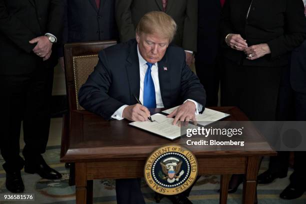 President Donald Trump signs a presidential memorandum targeting China's economic aggression in the Diplomatic Room of the White House in Washington,...