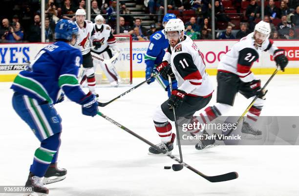Brendan Leipsic of the Vancouver Canucks looks on as Brendan Perlini of the Arizona Coyotes skates up ice with the puck during their NHL game at...