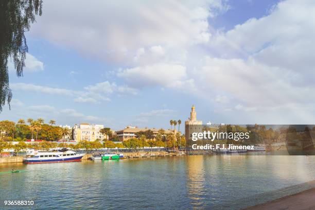 cityscape of seville with the guadalquivir river and the torre del oro - torre del oro stock pictures, royalty-free photos & images