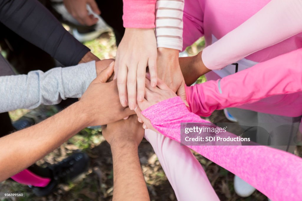 Grupo de personas con sus manos juntas en la unidad