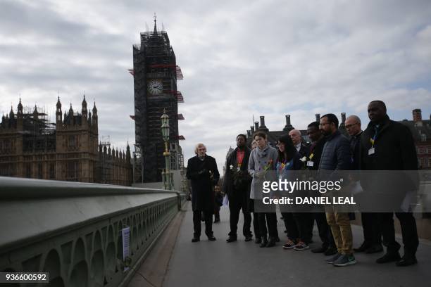 Hospital staff hold flowers on Westminster Bridge in central London on March 22 a year to the day after the Westminster terror attack. - Britain on...