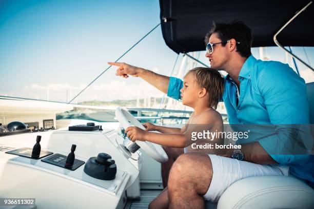 vater und sohn in den ferien - kid sailing stock-fotos und bilder