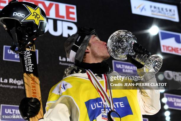 Alex Ferreira kisses the crystal globe trophy on the podium on March 22, 2018 during the price ceremony after competing in the Men's ski superpipe...