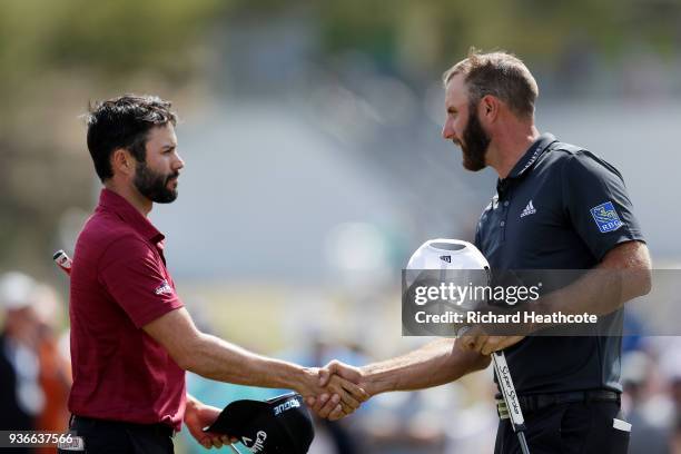 Adam Hadwin of Canada shakes hands with Dustin Johnson of the United States after defeating him 4&3 on the 15th green during the second round of the...