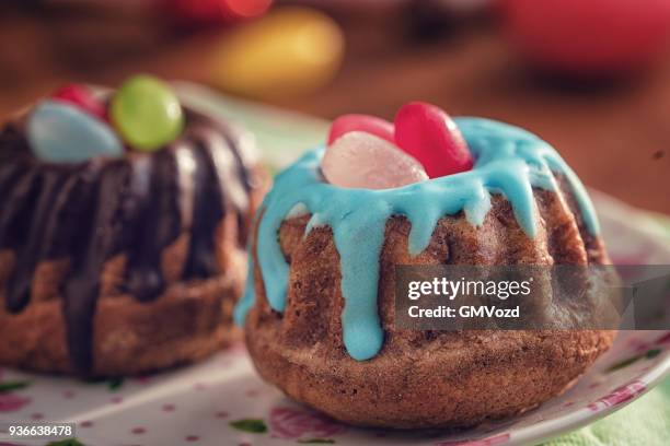 small easter bunt cakes with icing and sweets - bunt cake stock pictures, royalty-free photos & images