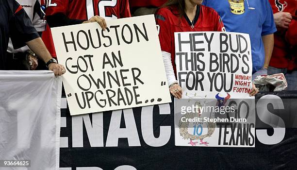 Houston Texans fans hold signs referring to Titans ownere Bud Adams gesturing to Buffalo Bills fans the previous week during the game with the...