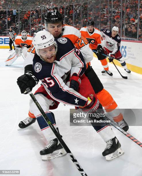 Scott Laughton of the Philadelphia Flyers battles in the corner against Mark Letestu of the Columbus Blue Jackets on March 15, 2018 at the Wells...
