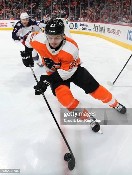 Scott Laughton of the Philadelphia Flyers skates the puck against Jack Johnson of the Columbus Blue Jackets on March 15, 2018 at the Wells Fargo...