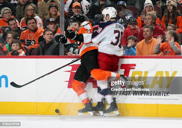 Scott Laughton of the Philadelphia Flyers battles for the puck along the boards against Boone Jenner of the Columbus Blue Jackets on March 15, 2018...