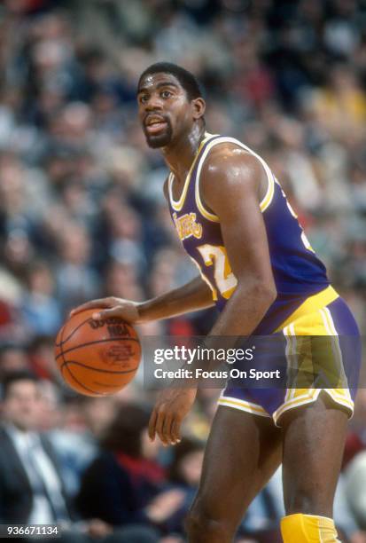 Earvin Magic Johnson of the Los Angeles Lakers dribbles the ball against the Washington Bullets during an NBA basketball game circa 1984 at the...