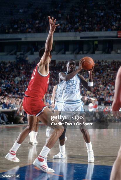 Michael Jordan of the North Carolina Tar Heels looks to pass the ball during an NCAA basketball game circa 1982 at the Greensboro Coliseum in...