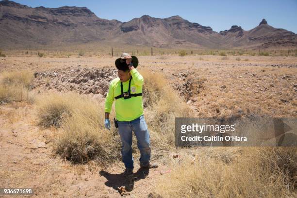 Aguílas del Desierto search and rescue crew member Jose Genis looks around at bone fragments of a migrant on May 27, 2017 in the Cabeza Prieta...