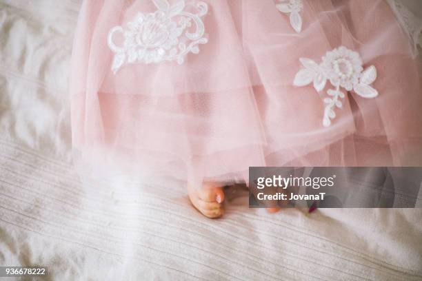 baby's feet under lovely pink wedding dress with flowers - jovanat stock pictures, royalty-free photos & images