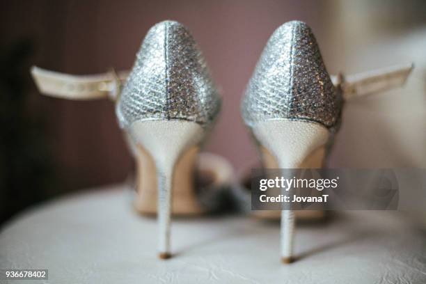 brides silver high heels on bed - zilverkleurige schoen stockfoto's en -beelden