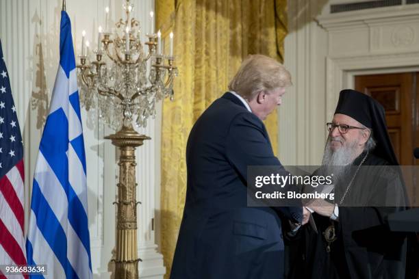 Archbishop Demetrios of America, elder archbishop of the Greek Orthodox Archdiocese of America, right, shakes hands with U.S. President Donald Trump...