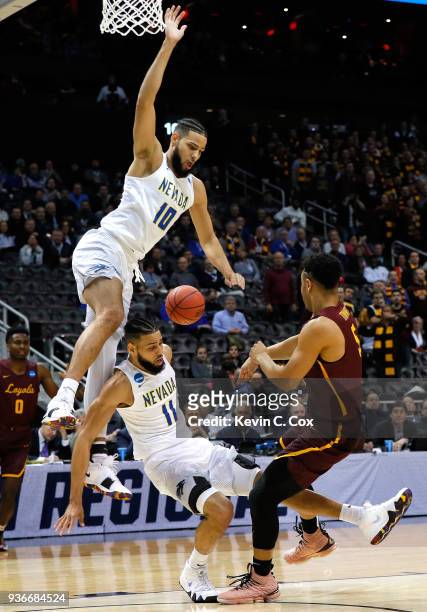 Marques Townes of the Loyola Ramblers passes as he collides with Cody Martin and Caleb Martin of the Nevada Wolf Pack during the 2018 NCAA Men's...