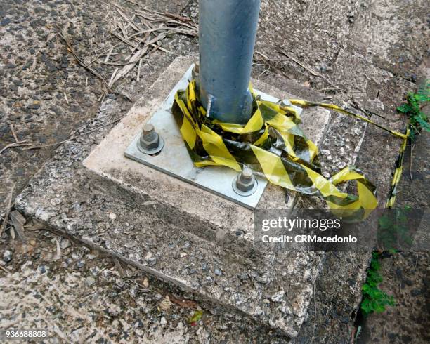 public light pole base, fixed to the floor with screws, and remnants of signaling tape. - crmacedonio 個照片及圖片檔