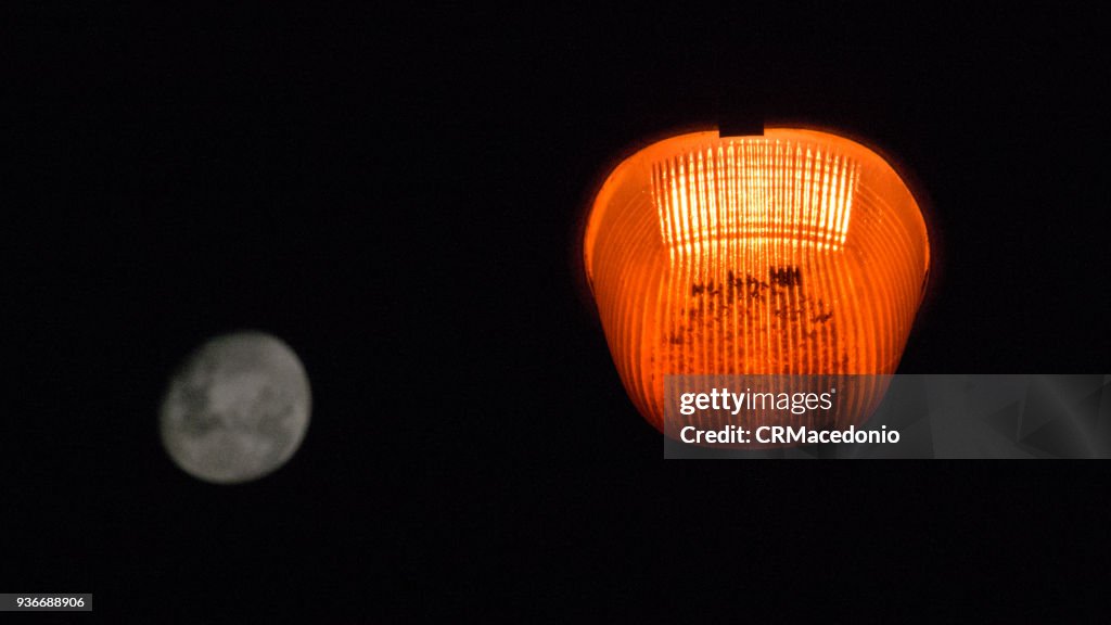 The contrast of public lighting with the full moon