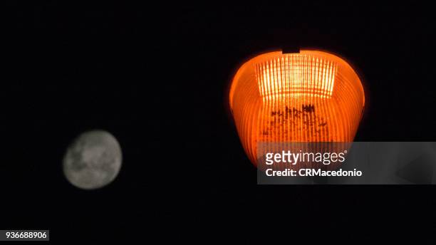 the contrast of public lighting with the full moon - crmacedonio foto e immagini stock