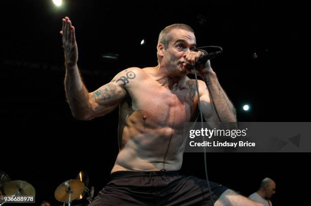 Rollins Band at Nokia Theater. Henry Rollins, one palm raised high, looks in challenge directly at audience as he sings in performance with Rollins...