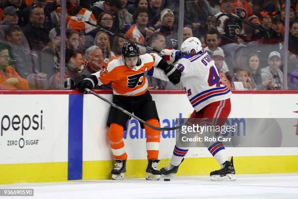 Valtteri Filppula of the Philadelphia Flyers and Rob O'Gara of the New York Rangers go after the puck in the first period at Wells Fargo Center on...