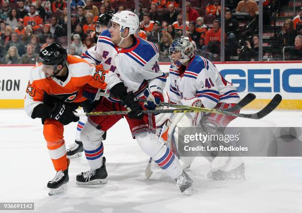 Brandon Manning of the Philadelphia Flyers, playing in his 200th career NHL game, battles for position in front of goaltender Alexandar Georgiev of...