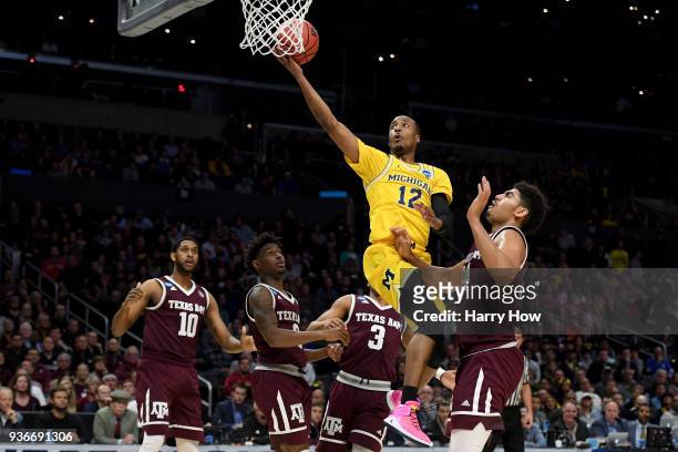 Muhammad-Ali Abdur-Rahkman of the Michigan Wolverines goes up for a shot against Tyler Davis of the Texas A&M Aggies in the first half in the 2018...