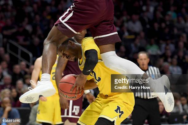 Muhammad-Ali Abdur-Rahkman of the Michigan Wolverines with the ball against Robert Williams of the Texas A&M Aggies in the first half in the 2018...