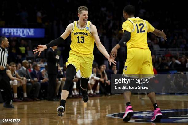 Moritz Wagner celebrates with Muhammad-Ali Abdur-Rahkman of the Michigan Wolverines after Wagner makes a three-pointer in the first half against the...
