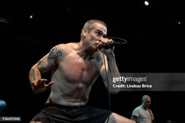 Rollins Band at Nokia Theater. Henry Rollins raises his brow as he looks intensely to the audience, his right palm at 45-degree angle to stage floor...