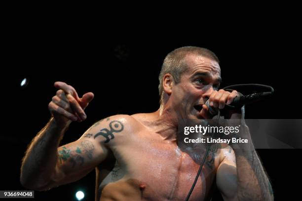 Rollins Band at Nokia Theater. Henry Rollins points toward his right, his brow furrowed as he looks directly at audience as he sings in performance...