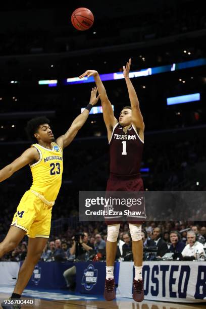 Hogg of the Texas A&M Aggies attempts a shot defended by Ibi Watson of the Michigan Wolverines during the first half in the 2018 NCAA Men's...