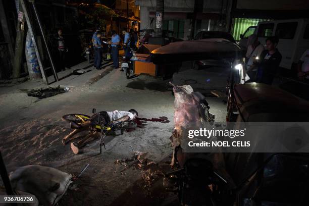 The body of an alleged drug dealer lies on the ground after he was killed by an unidentified assailant in Manila on March 23, 2018. Philippine police...