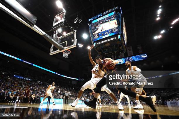 Clayton Custer of the Loyola Ramblers handles the ball against Josh Hall and Cody Martin of the Nevada Wolf Pack in the second half during the 2018...