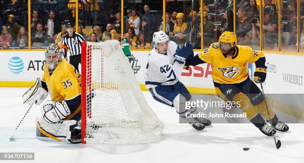 Subban of the Nashville Predators skates the puck behind the net against Tyler Bozak of the Toronto Maple Leafs as Pekka Rinne tends net during an...