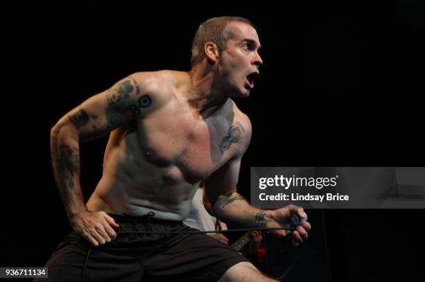Rollins Band at Nokia Theater. Henry Rollins, mouth agape as in alarm, his arms down and back as if to charge toward audience as he sings in...
