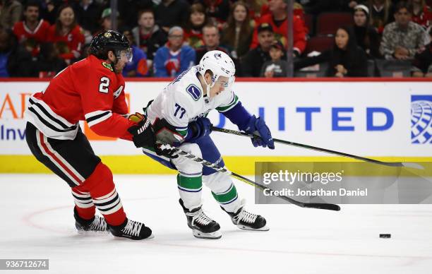 Nikolay Goldobin of the Vancouver Canucks advances the puck in front of Duncan Keith of the Chicago Blackhawks at the United Center on March 22, 2018...