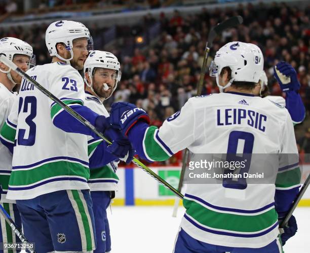 Alexander Edler of the Vancouver Canucks is congratulated by Brendan Leipsic after scoring a first period goal against the Chicago Blackhawks at the...