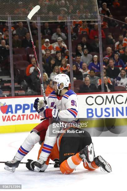 Mika Zibanejad of the New York Rangers falls onto Travis Sanheim of the Philadelphia Flyers in the third period at Wells Fargo Center on March 22,...