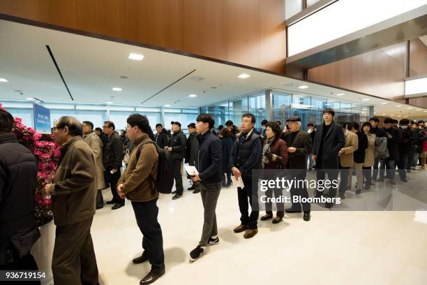 Shareholders stand in line to enter the Samsung Electronics Co. Annual general meeting at the company's Seocho office building in Seoul, South Korea,...